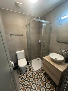 a bathroom with a shower and a toilet and a sink at Dahlia apartment - Paola Modern Townhouse in Paola +17 photos