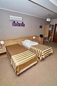 a hotel room with two beds and a desk at Hotel Soccer Sport in Radomsko
