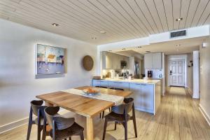 a kitchen and dining room with a wooden table and chairs at Land's End 11-203 Beach Front - Premier in St Pete Beach