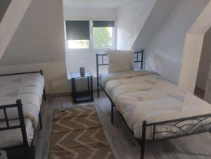 a room with two beds and a window at Maison de ville centrale in Vierzon