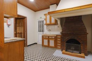 a kitchen with a brick fireplace in a room at BABhouse Lagar Antigo - Coração do Douro in Nagoselo do Douro