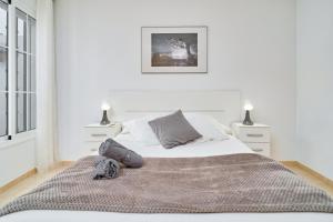 a white bedroom with a large bed and two night stands at Apartamento B y G Nerja in Nerja