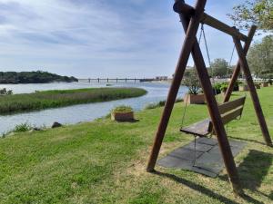 a swing with a river in the background at Ancora beira-mar in Vila Praia de Âncora