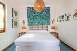 a bedroom with a white bed and two lamps at Stintino villa with view over Asinara Island in Stintino