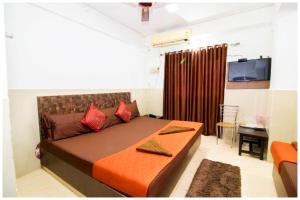 una camera da letto con un letto con cuscini rossi di HOTEL PREMIUM TRAVELLERS # iNN Near Temple - Fully Air Conditioning Hotel - Hygiene And Spacious Room - A Top Rated Luxuary Hotel a Merces
