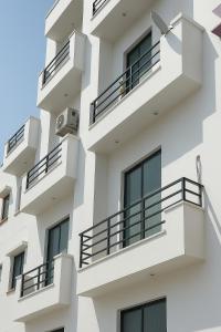 MalhourにあるVista Kove Flat - 101のバルコニー付きの白い建物