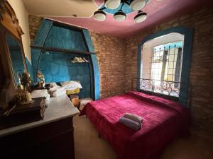 a bedroom with a red bed and a mirror at Casa storica Valentina in Monforte dʼAlba