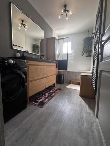 a bathroom with a washer and dryer in a room at Maison avec piscine chauffée, plages du débarquement in Crouay