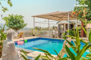 a villa with a swimming pool and a house at Nysa Villa & Homestays in Igatpuri