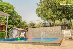 a pool with two chairs and a ball in the water at Nysa Villa & Homestays in Igatpuri