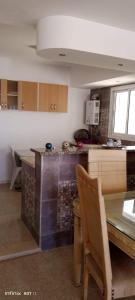 a kitchen with a table and a counter top at Dar yess in Bin Rhilouf