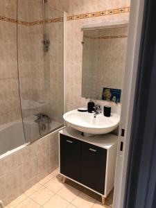 a bathroom with a sink and a mirror and a tub at Wool INN Le Colombier in Milly-la-Forêt