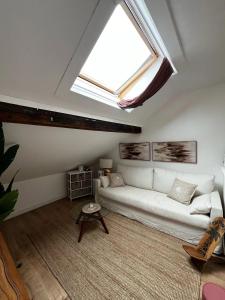 a living room with a white couch and a skylight at House in Jupille-sur-Meuse with terrace and barbecue in Jupille