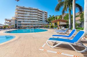 Un par de tumbonas junto a una piscina. en Luxury 2-Bedroom Ocean View Apartment, en Puerto de Santiago