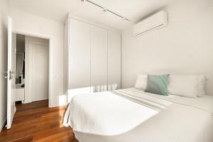 a white bedroom with a bed and a hallway at פנטהאוז מול הים - פנטהאוז יוקרתי בנאות גולף קיסריה in Caesarea