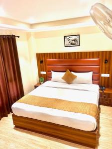 Kaisha Himalayan View في شيملا: غرفة نوم بسرير كبير مع لوح رأس خشبي