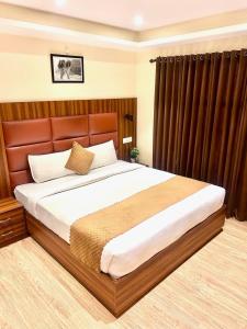 a bedroom with a large bed with a wooden headboard at Kaisha Himalayan View in Shimla