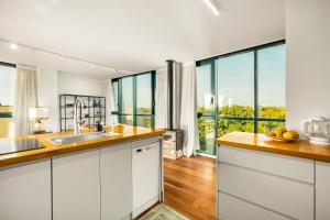 a kitchen with white cabinets and glass windows at פנטהאוז מול הים - פנטהאוז יוקרתי בנאות גולף קיסריה in Caesarea +31 photos