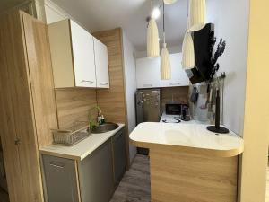 a small kitchen with white cabinets and a sink at SeaShell Studio Przymorze in Gdańsk