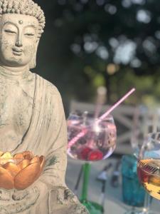 a statue of a buddha with a glass of wine at Bauernhofvilla nur für Frauen Woman only in Niemegk +27 photos