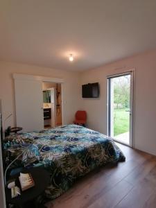 Un dormitorio con una cama con una manta colorida. en Bienvenue chez nous, en Mouchamps