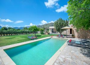 ein Swimmingpool mit zwei Stühlen und einem Haus in der Unterkunft Villa Vinya Frares - Luxury Retreat in Pollença