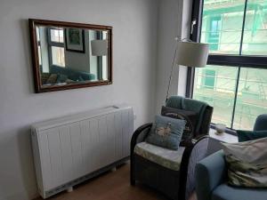 a living room with a chair and a mirror at Seaview Loft 20 Portrush in Portrush