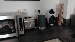 a kitchen with a microwave and various appliances at Seaview Loft 20 Portrush in Portrush +7 photos
