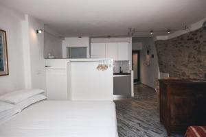 una stanza bianca con un letto e una cucina di Costellino 5 Terre a Riomaggiore