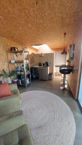 Oud-AdeにあるHut-Spot, comfortabel houten tuinhuisのリビングルーム(ソファ、大きなラグ付) +13枚の写真