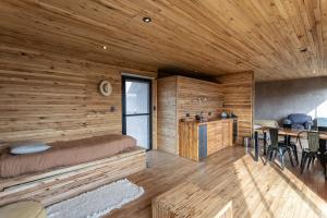a log cabin with a bed and a table at La Calma Ecolodge 2 in Las Heras