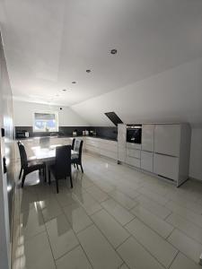 a dining room with a table and chairs and a kitchen at Ferienwohnung Garath Nord Sendenhorst in Sendenhorst +12 photos