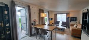 ein Wohnzimmer mit Esstisch und ein Wohnzimmer in der Unterkunft Chalet Hart van Zeeland met overdekt terras & natuur VP086 in Heinkensand