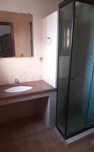 Un baño con lavabo y ducha de cristal. en Hospedaria Clã do Cla, en Arraial do Cabo