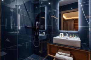 ein Badezimmer mit Waschbecken und Spiegel in der Unterkunft Madame Vacances Résidence L'Orée du Bois in La Rosière + 119 Fotos