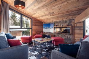 ein Wohnzimmer mit roten Stühlen und einem Steinkamin in der Unterkunft Madame Vacances Résidence L'Orée du Bois in La Rosière