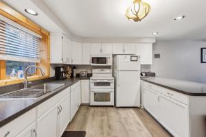 une cuisine avec des armoires blanches et des appareils électroménagers blancs dans l'établissement Tannery 64H - Family Retreat with Modern Comforts, à North Creek