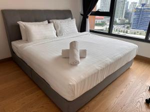 a bedroom with a large bed with two towels on it at Lucentia Residence by EAS Maju property in Kuala Lumpur