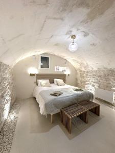 a white bedroom with a bed and a table at Maison de Charme Centre Roquette, 3 chambres in Arles