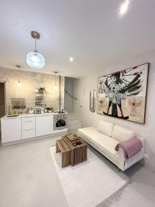 a living room with a white couch and a kitchen at Maison de Charme Centre Roquette, 3 chambres in Arles