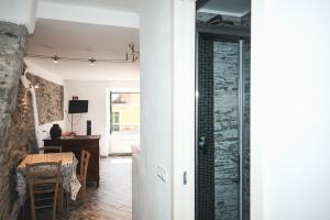 un corridoio con una stanza con tavolo e porta a vetri di Costellino 5 Terre a Riomaggiore