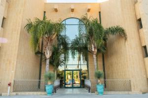 two palm trees in front of a building at פנטהאוז מול הים - פנטהאוז יוקרתי בנאות גולף קיסריה in Caesarea