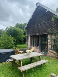 einem Picknicktisch vor einem Haus in der Unterkunft Maison au bord de riviere , proche de la mer- spa semi rigide plein air en option in Bacqueville-en-Caux