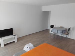 Room Benjamin في بوريتش: غرفة معيشة بها سرير وطاولة وتلفزيون +10 صور