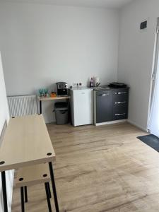 a small kitchen with a table and a refrigerator at LaLa HOME in Oradea