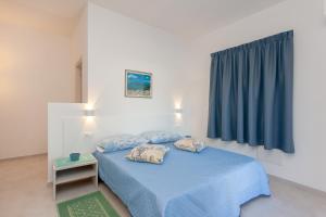 a bedroom with a blue bed with two pillows at Domo Davide in San Teodoro