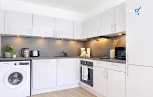 a kitchen with white cabinets and a washer and dryer at BEGE APARTMENTS BizConnect in Wuppertal +13 photos