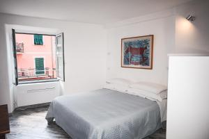 una camera da letto bianca con un letto e una finestra di Costellino 5 Terre a Riomaggiore