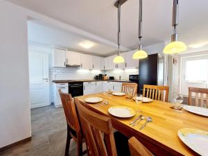 a kitchen with a wooden table with chairs and a dining room at Ferienhaus im Koog in Tetenbüll