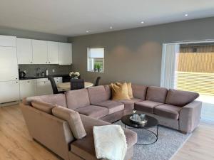sala de estar con sofá marrón y cocina en Eksklusiv leilighet med spektakulær utsikt, en Kabelvåg